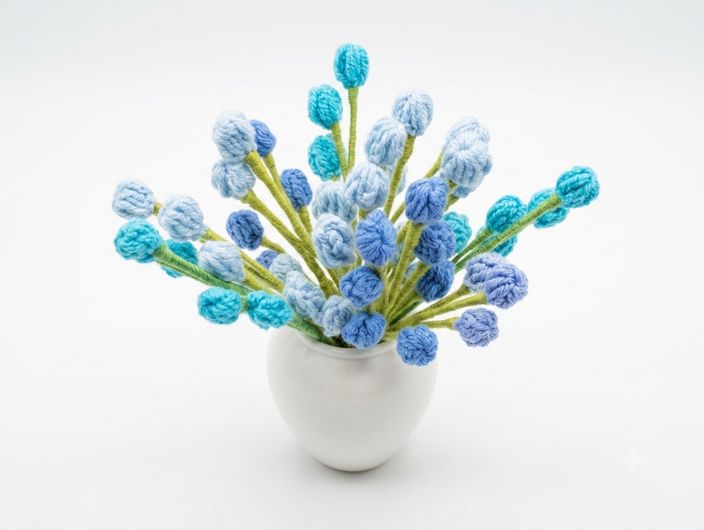 Handcrafted crochet bobble bud arrangement in blue and teal in white vase on white background