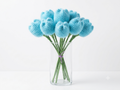 A bunch of blue fuzzy crochet tulips with green stems in a tall glass vase against a white background