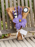 Handmade crochet purple bouquet on a wooden bench